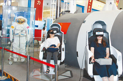 图为参观者通过VR（虚拟现实）设备体验宇航员出舱的过程。
